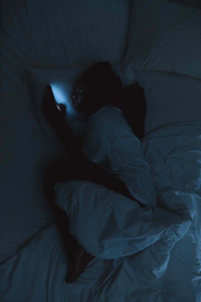 A phone glowing in a dark bedroom late at night